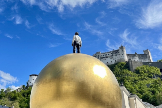 Man standing on big golden ball