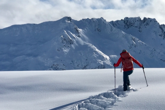 Woman walking through the snow in the mountains