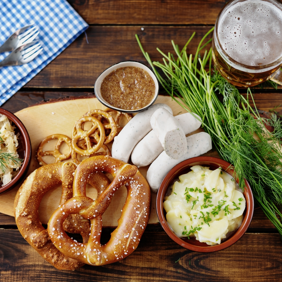 Beer mug with pretzels and sausage on a wooden table